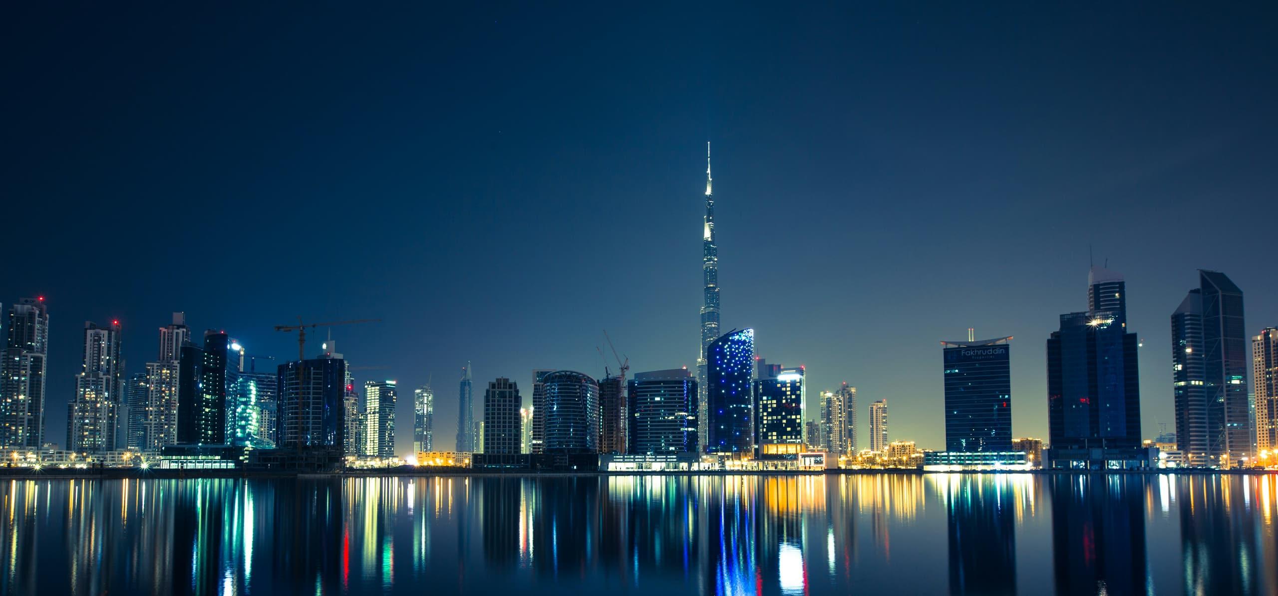 Dubai skyline at night reflected in the water