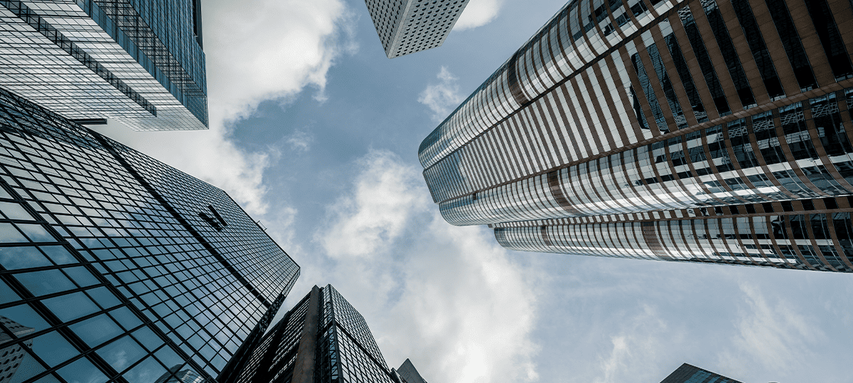 Looking up at a cluster of modern skyscrapers